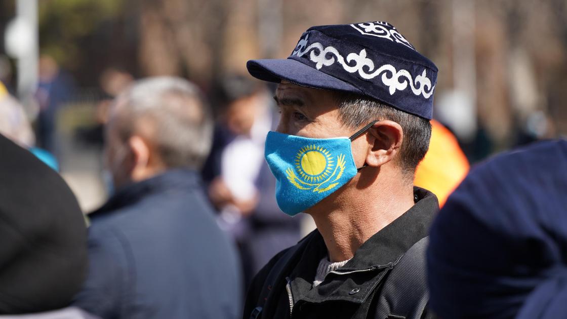 Мужчина в маске с флагом Казахстана
