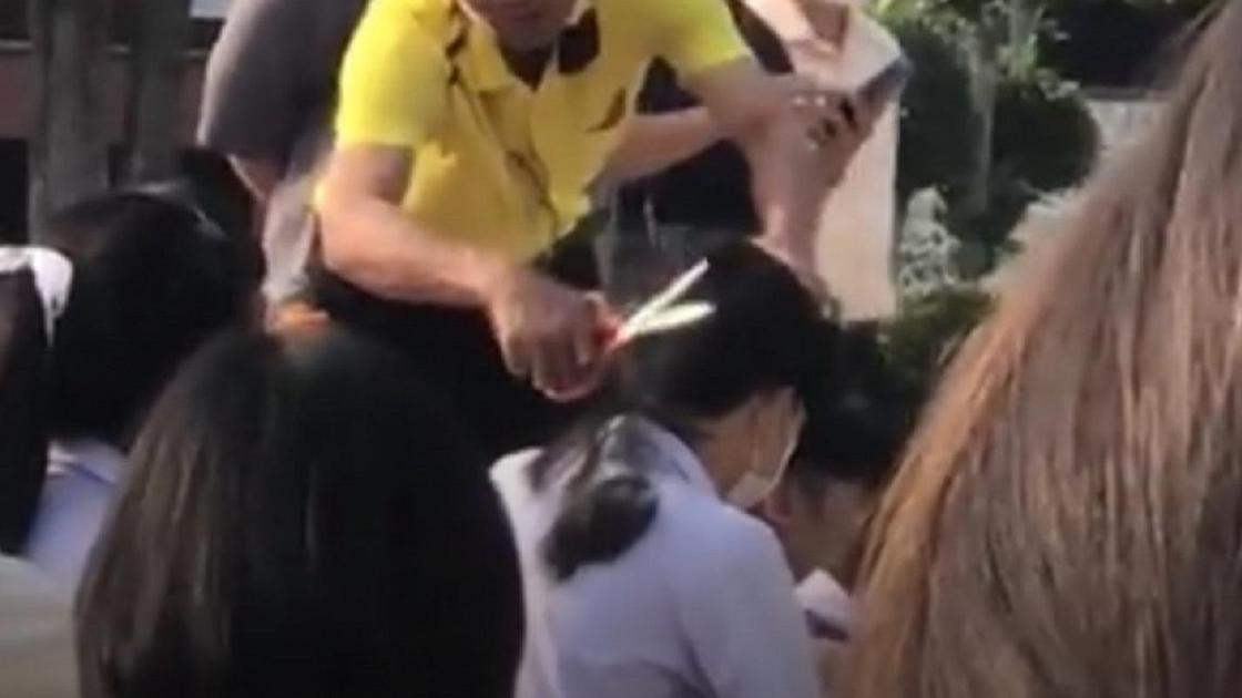 Учитель отрезает волосы школьникам