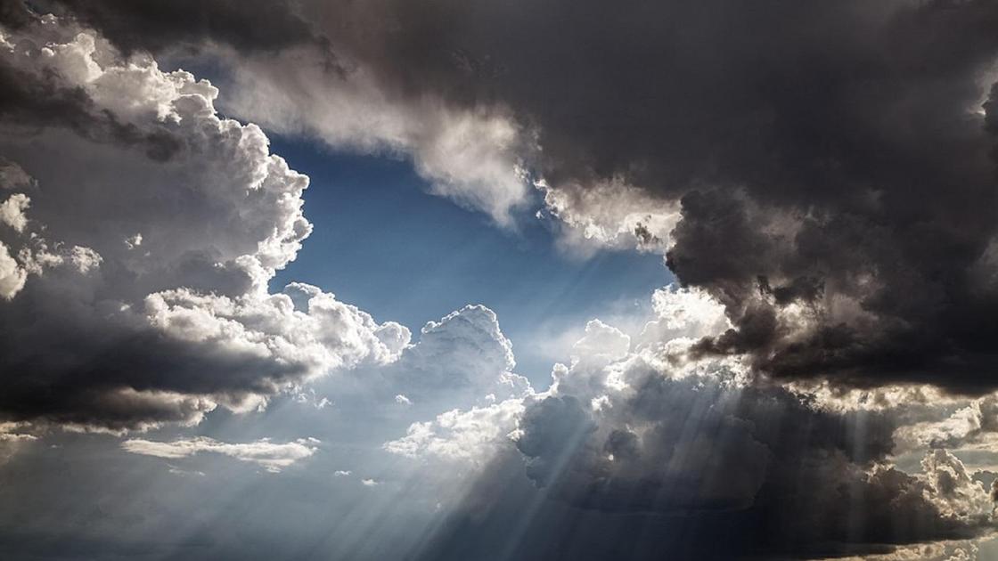 Бұлтты күннің арасынан түскен күн сәулесі