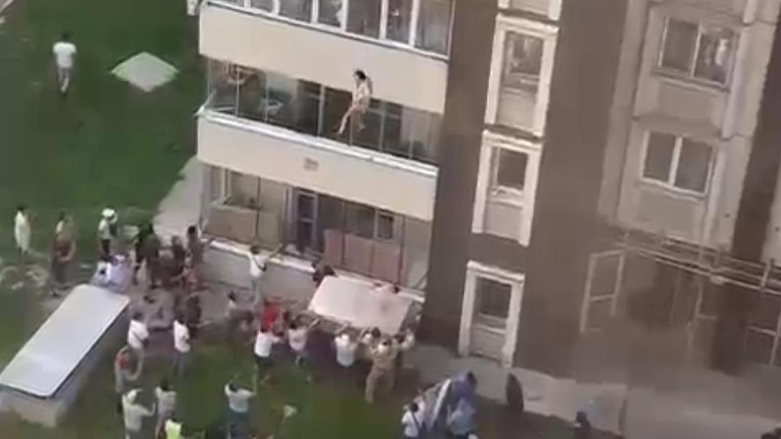 Женщина прыгает из окна многоэтажного дома