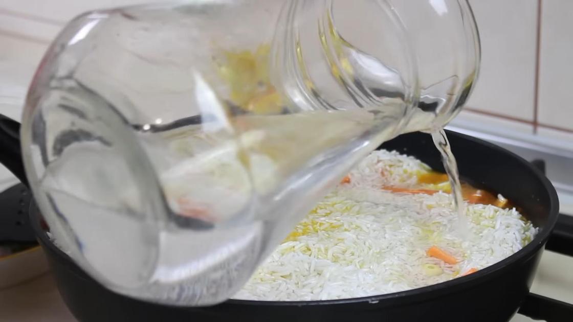 Воду из графина наливают в сковороду с рисом