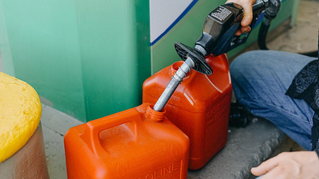 Мужчина наливает топливо в канистры