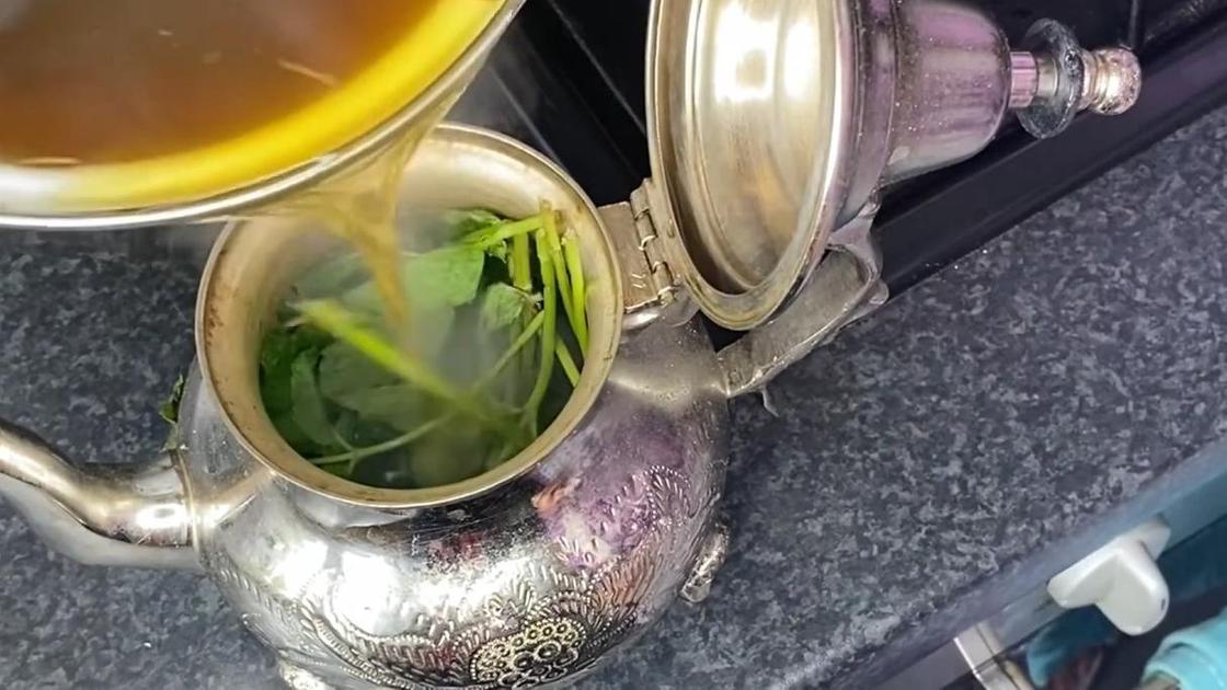 Переливание чая в чайник со свежей мятой