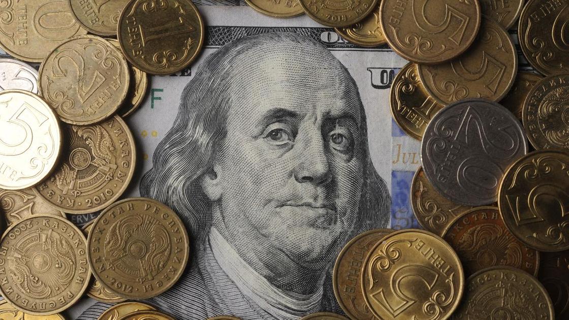 Долларовая банкнота лежит под монетами
