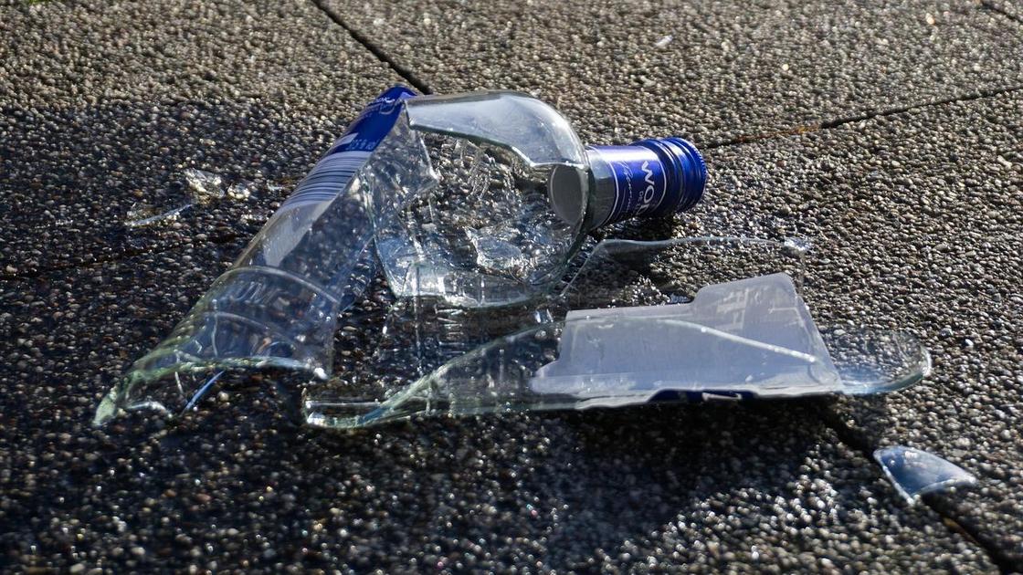 Разбитая бутылка лежит на земле