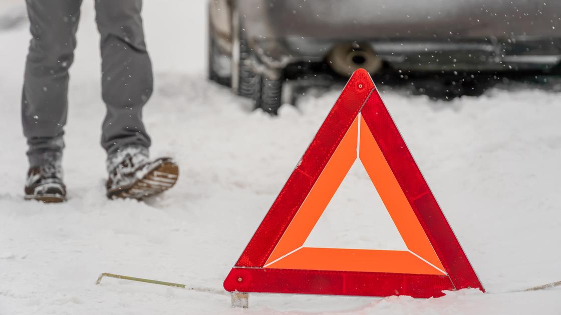 Человек идет мимо предупреждающего знака