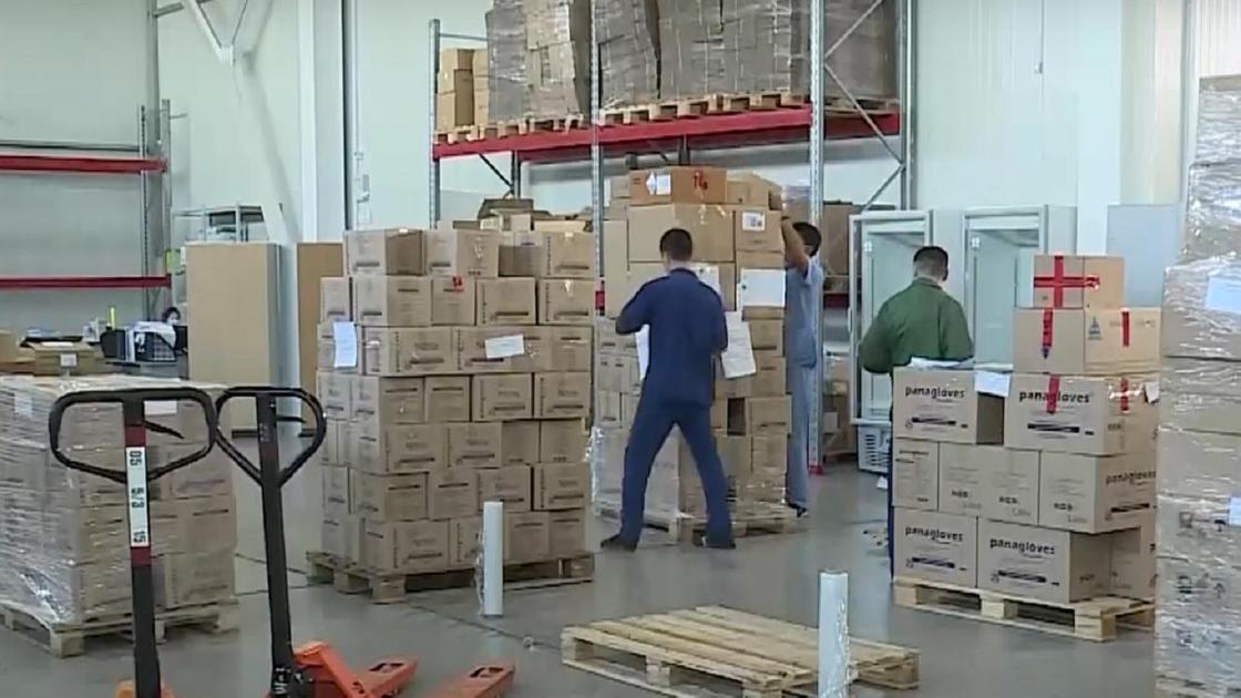Мужчины укладывают коробки на складе