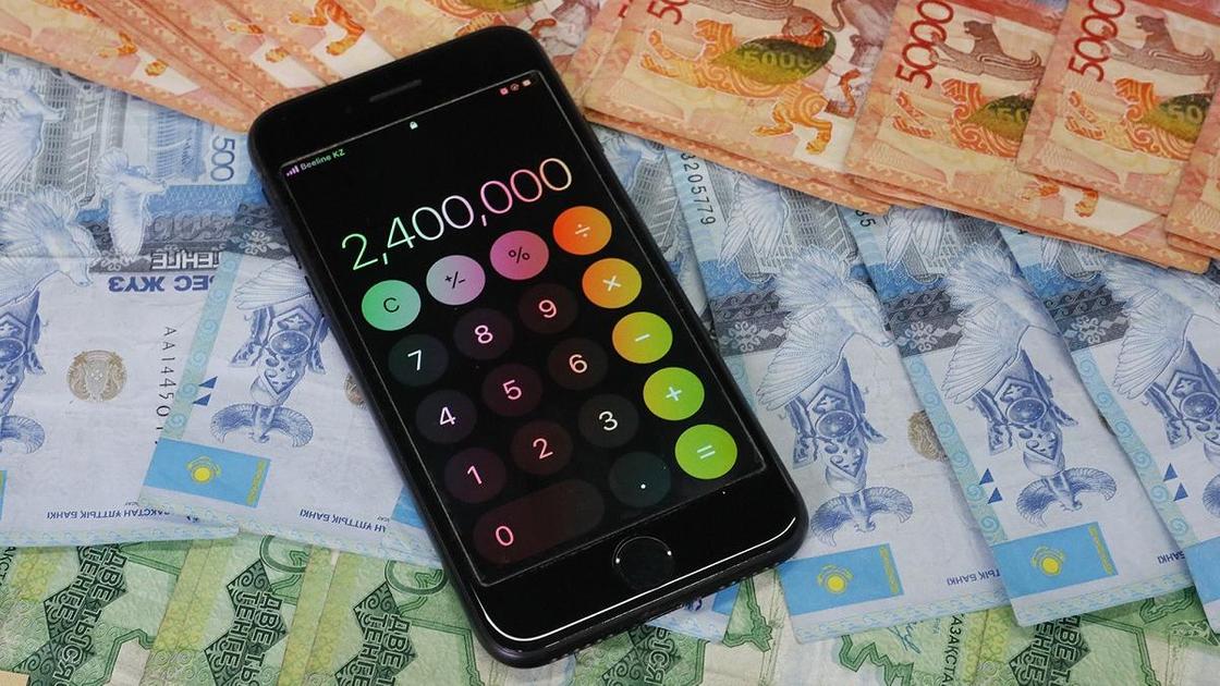 Телефон с открытым калькулятором лежит на деньгах