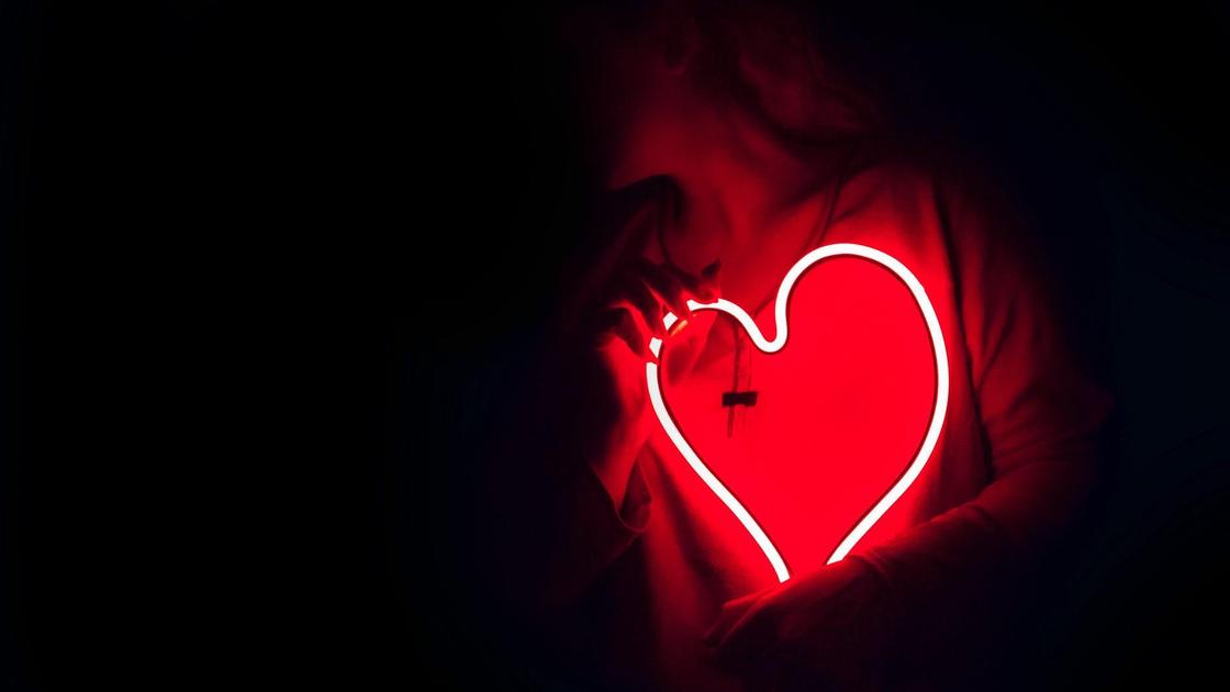 Девушка держит LED-лампу в форме сердца