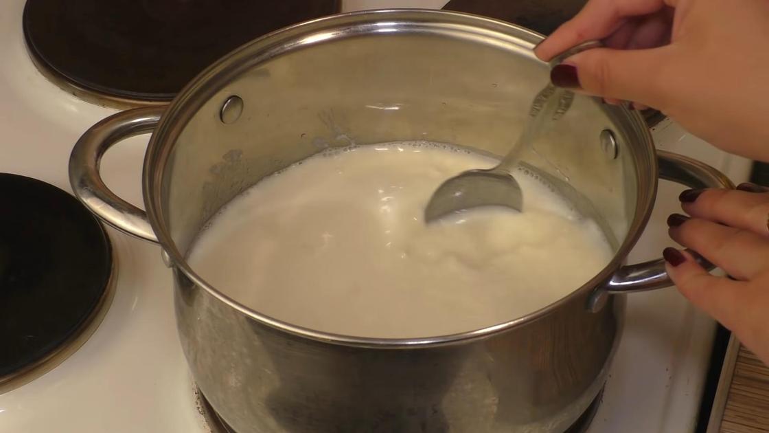 Молоко размешивают в кастрюле ложкой