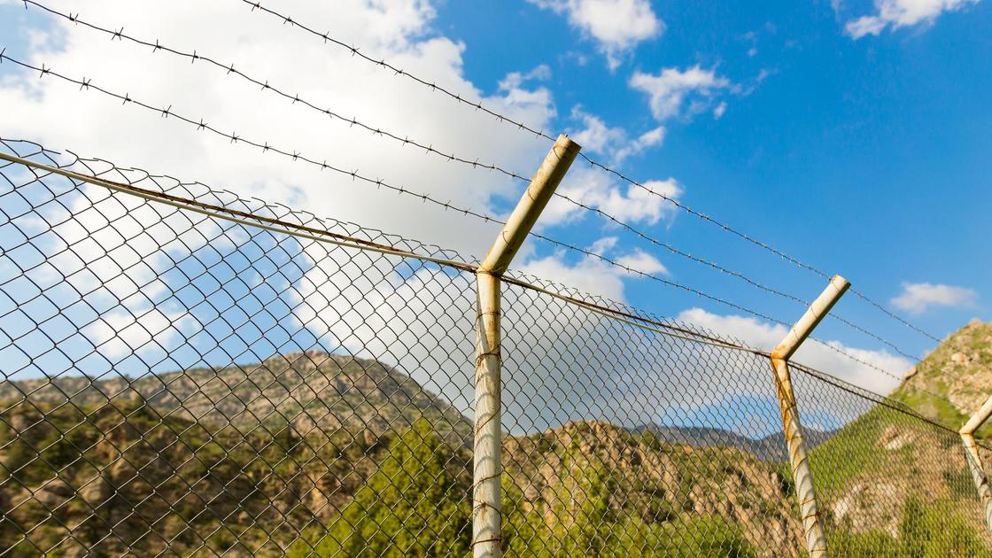 Забор с колючей проволокой в горах