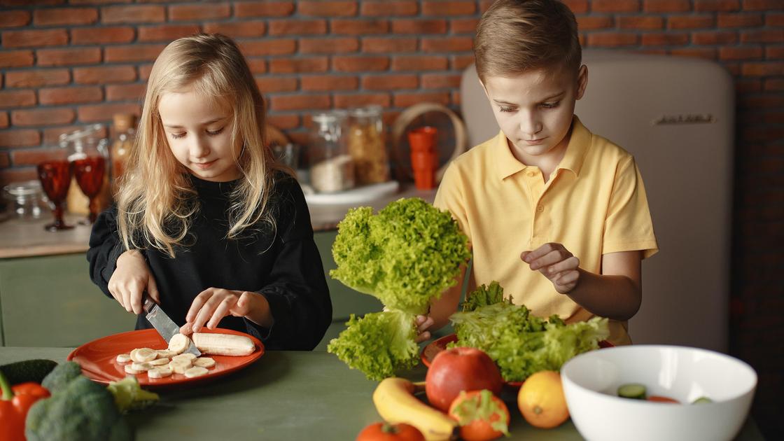 Дети режут фрукты и овощи