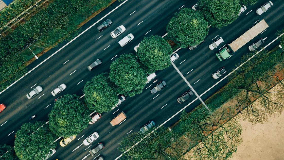 По дороге на несколько полос движутся легковые и грузовые автомобили