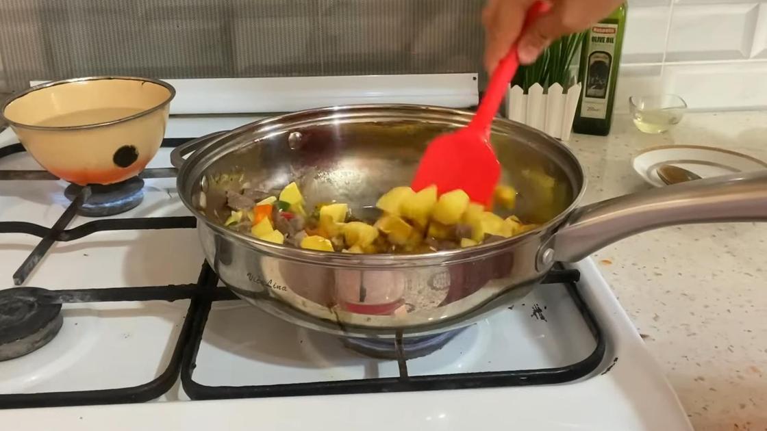 В сковороде на плите перемешивают картофель с овощами