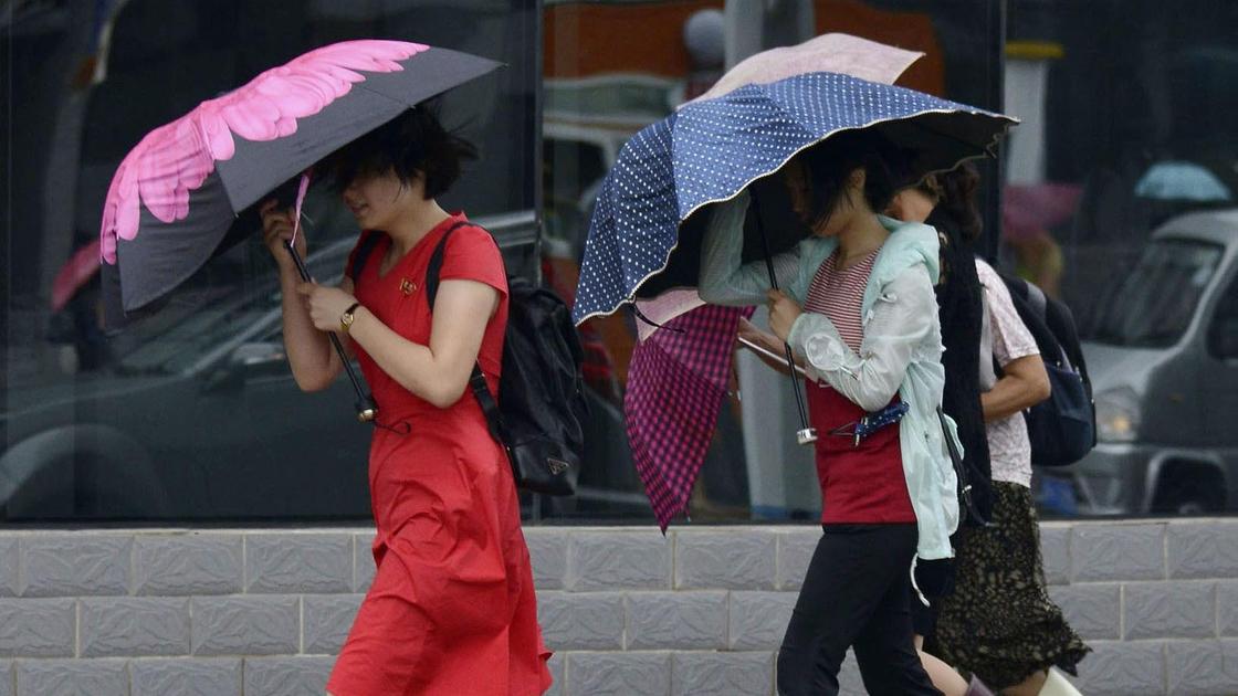 девушки идут под зонтами