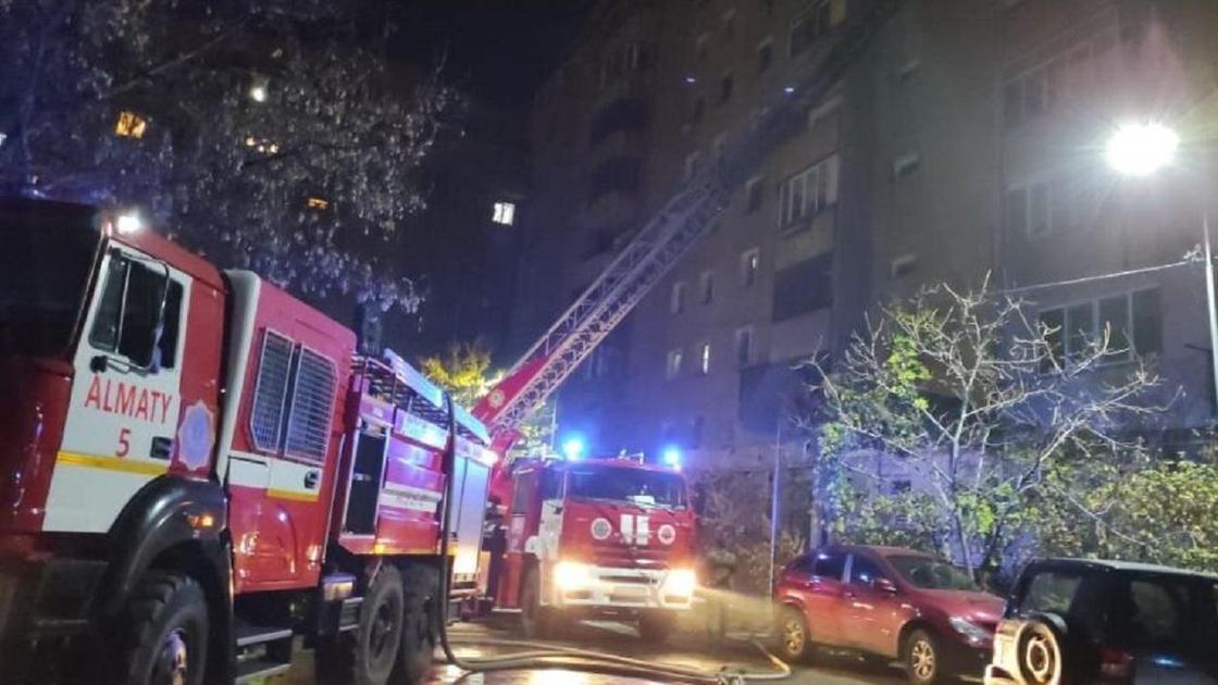 Пожарные машины стоят у горящего здания
