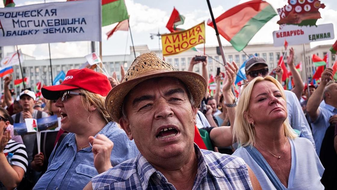 Мужчина в шляпе выступает на митинге в поддержку Лукашенко