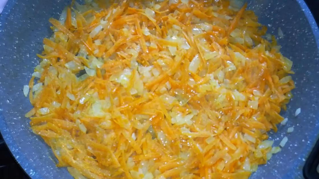 На сковороде обжаривается нарезанный репчатый лук и натертая морковь