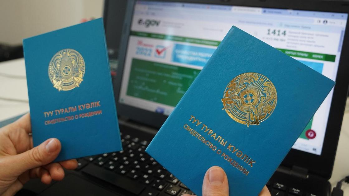 Туу туралы куәлікті ұстап тұрған әйел