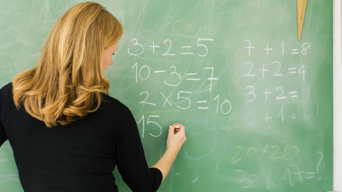 Учитель пишет пример на доске