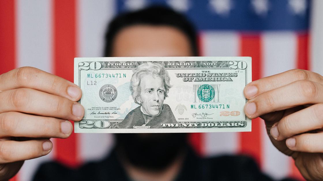 20-долларовая купюра на фоне флага США