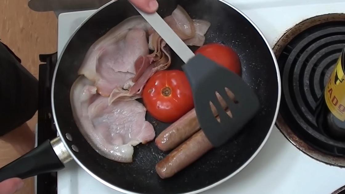 Приготовление бекона на сковороде с сосисками и помидором