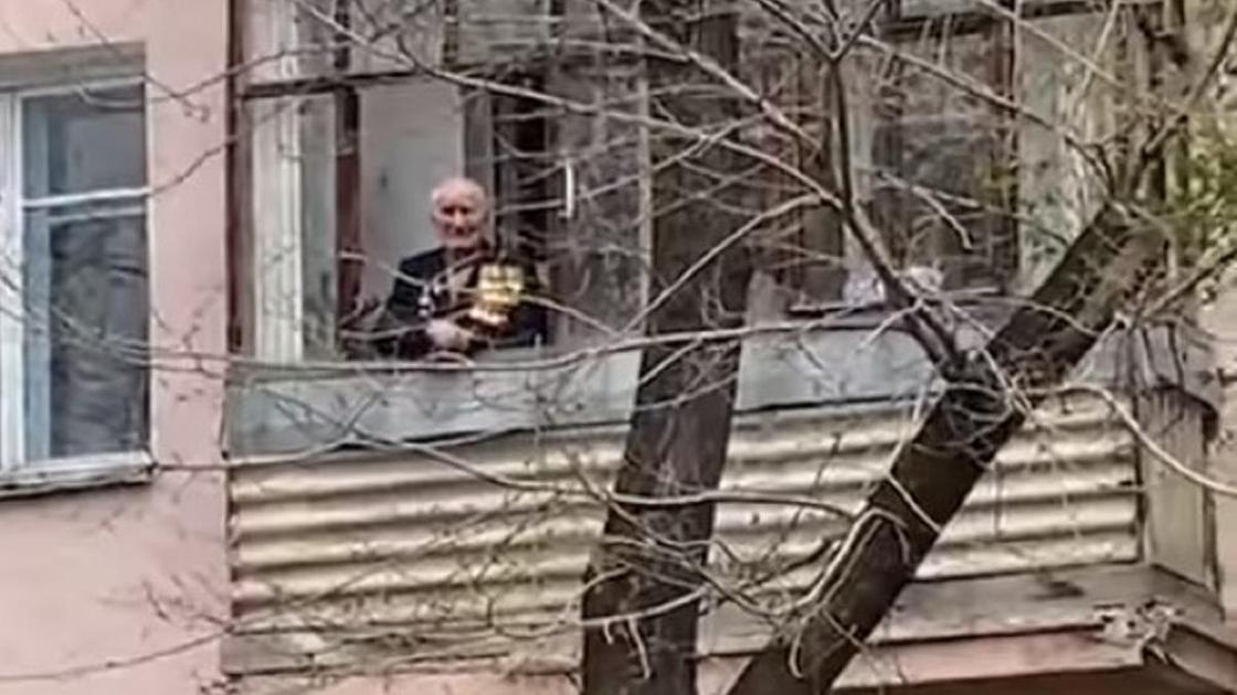 Ветеран Николай Гугняк слушает песню "День Победы"
