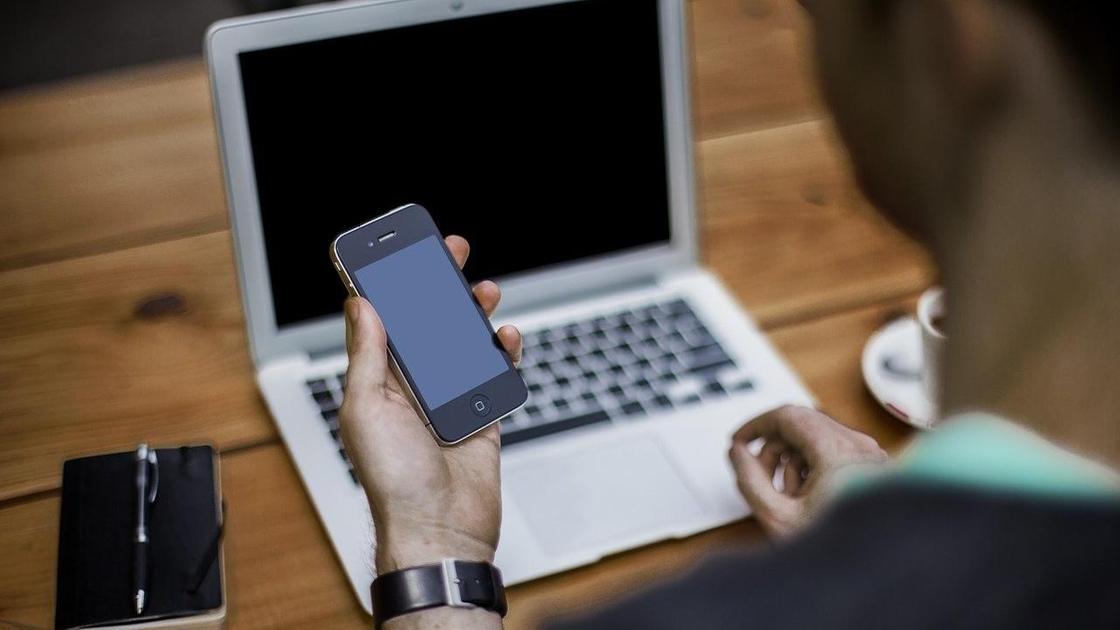 Мужчина держит сотовый телефон