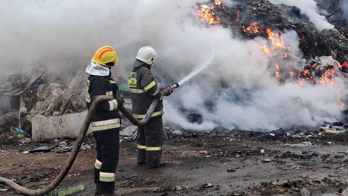 Пожарные тушат пожар на полигоне