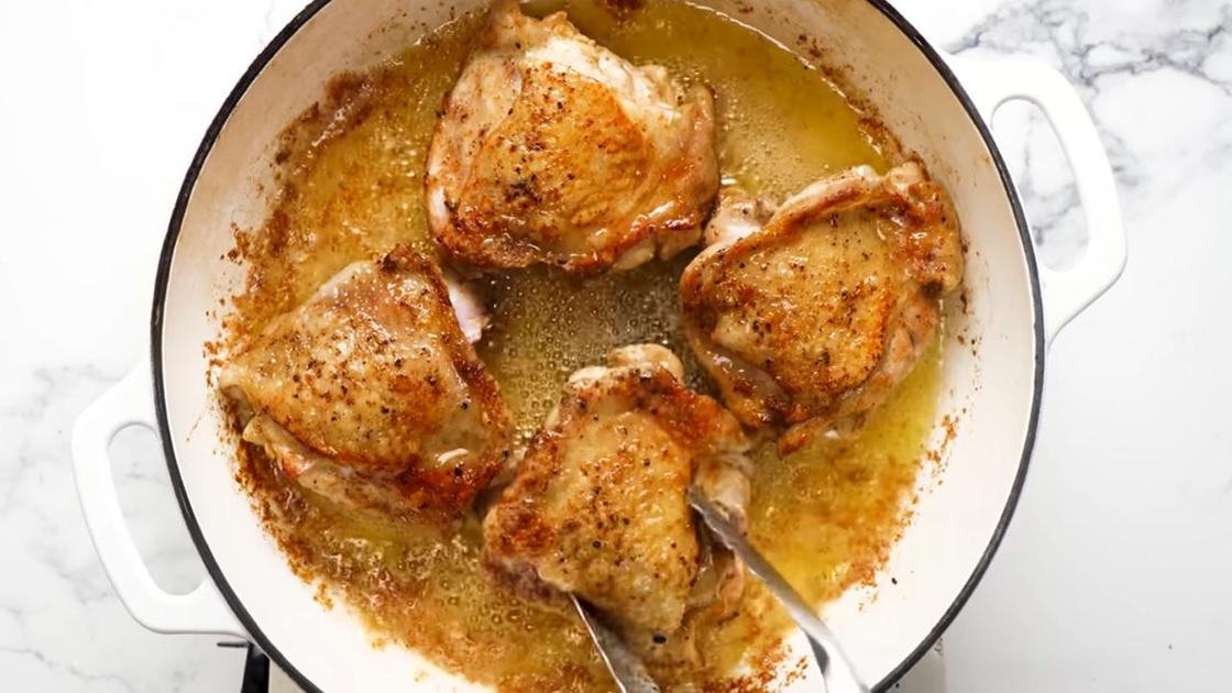 В сковороде с маслом обжаривают куриные бедра