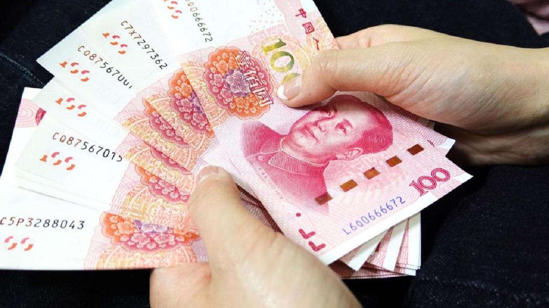 Купюры китайских юаней в руках