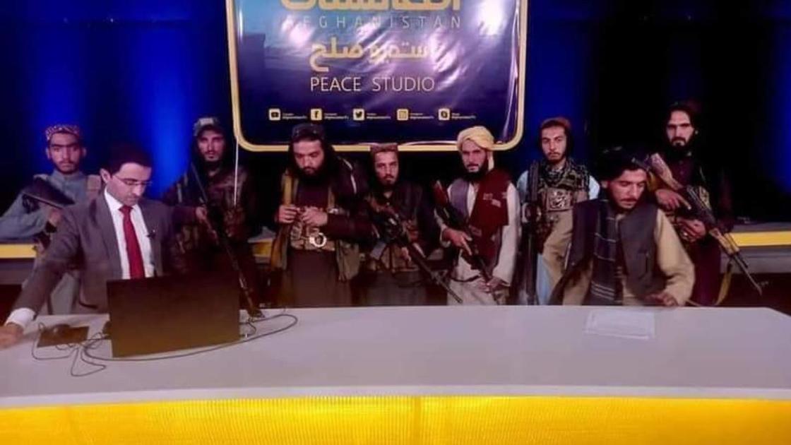 Журналист телевидения в окружении вооруженных талибов
