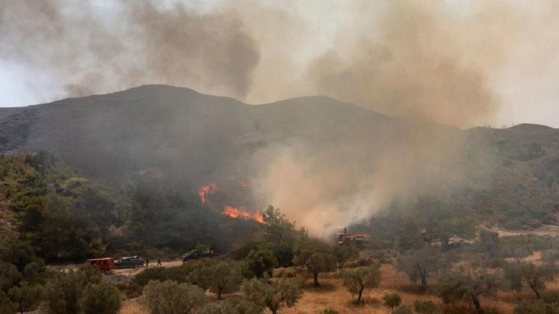 Дым и огонь среди холмов в Греции
