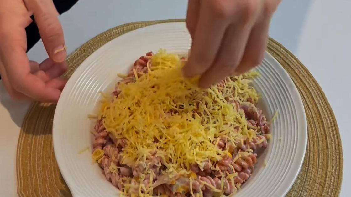 Салат с макаронами посыпают сыром