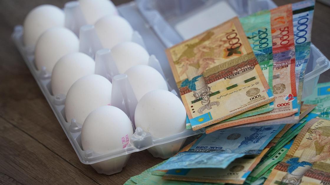 Банкноты лежат рядом с упаковкой с яйцами