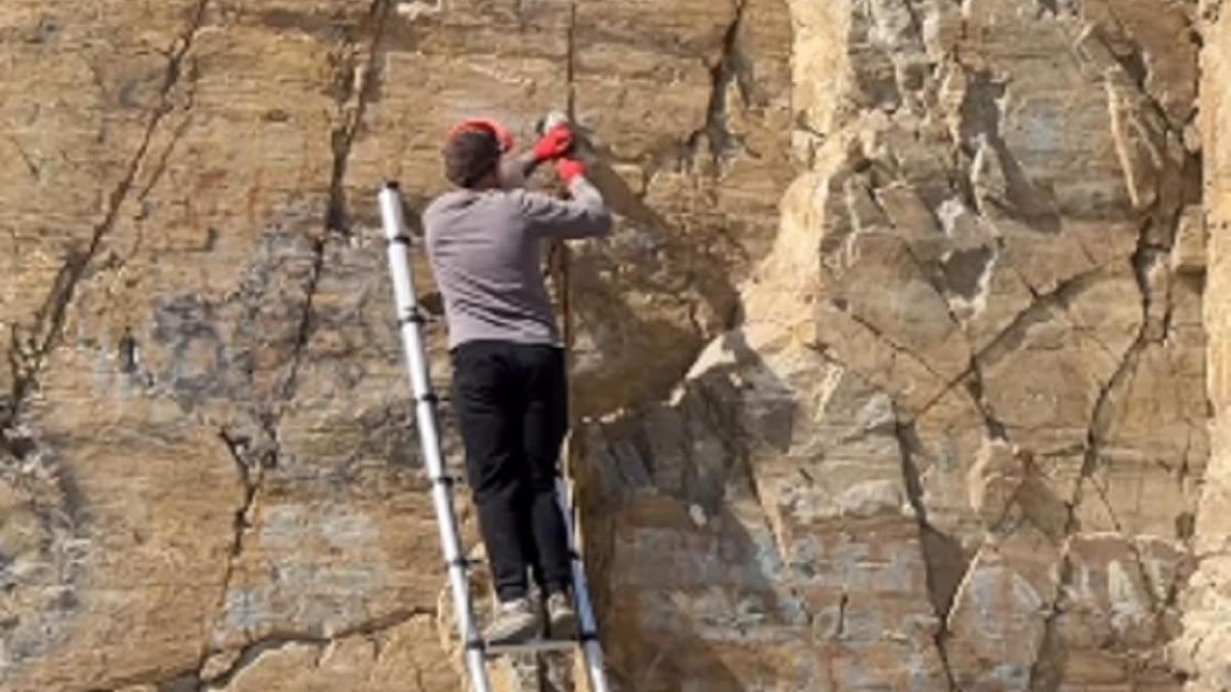 Житель ВКО очищает скалы от надписей