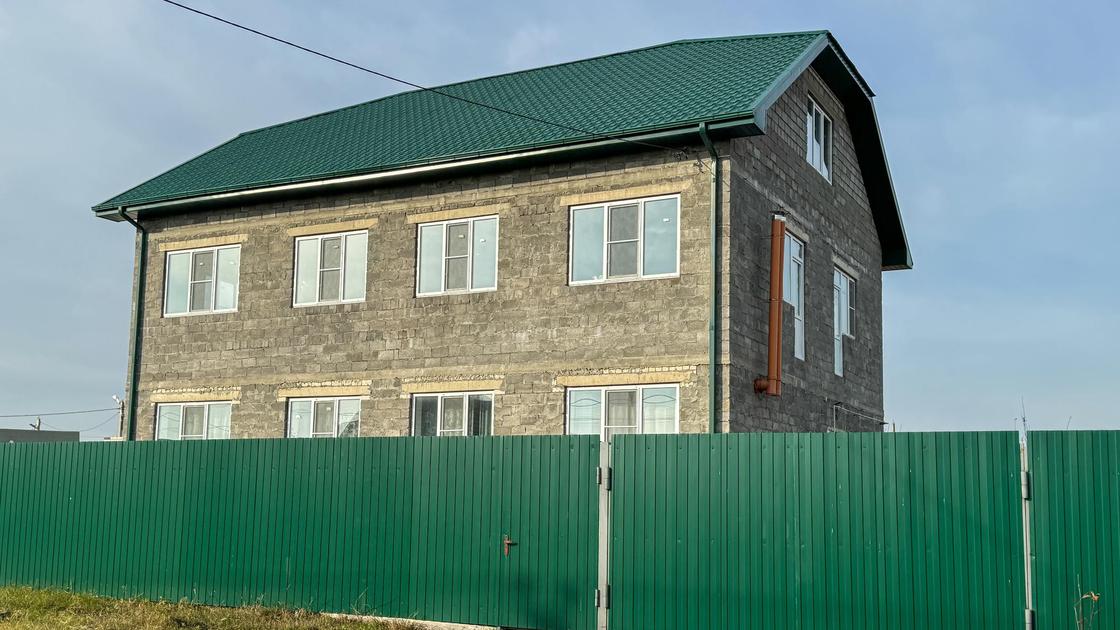 Двухэтажный дом за забором