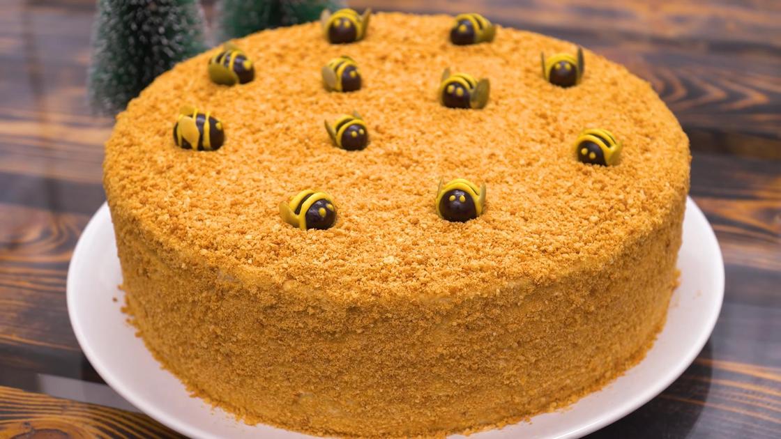 Торт «Медовик» на сервировочной тарелке с декором в виде пчел