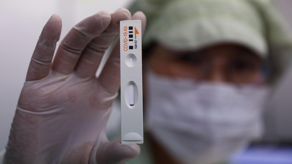 Медик держит тест на коронавирус
