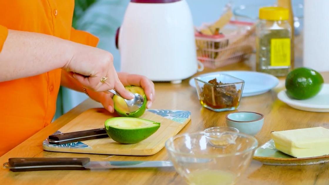 Из половинки авокадо извлекают мякоть при помощи ложки