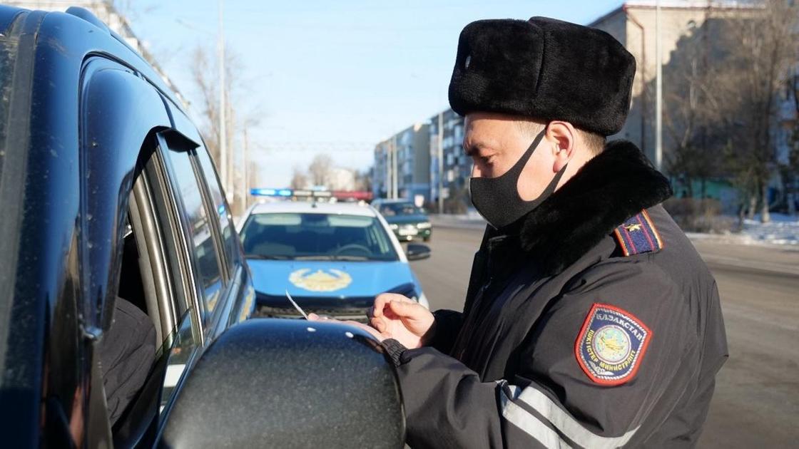 полицейский проверяет документы у водителя
