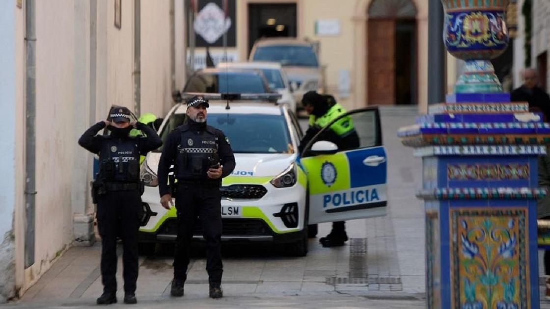 Испанские полицейские стоят перед машиной на улице