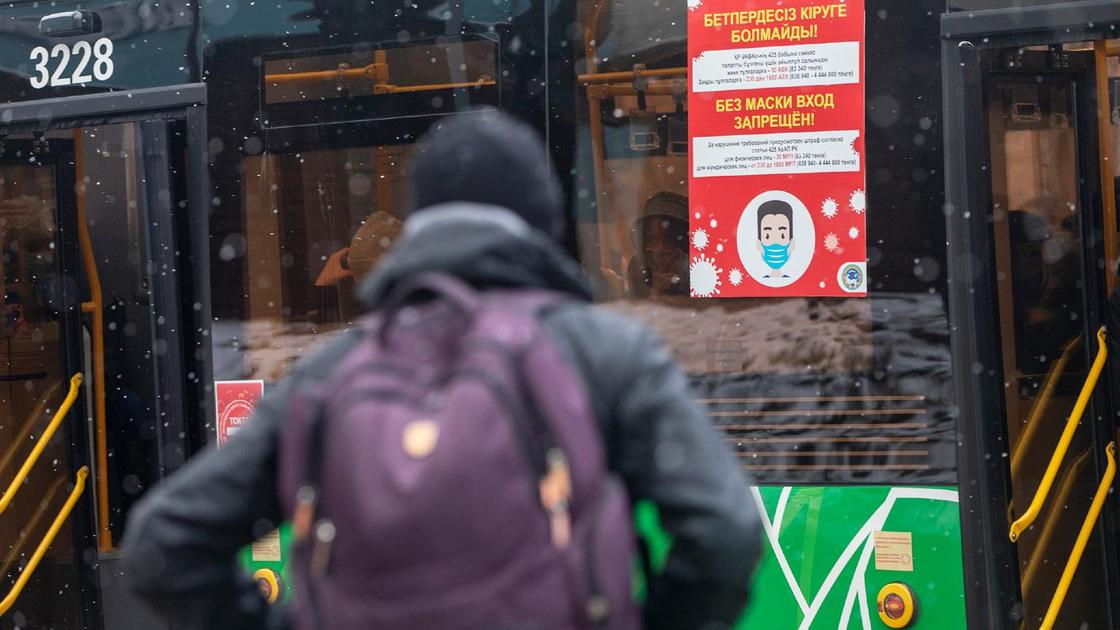 Мужчина с рюкзаком стоит возле автобуса