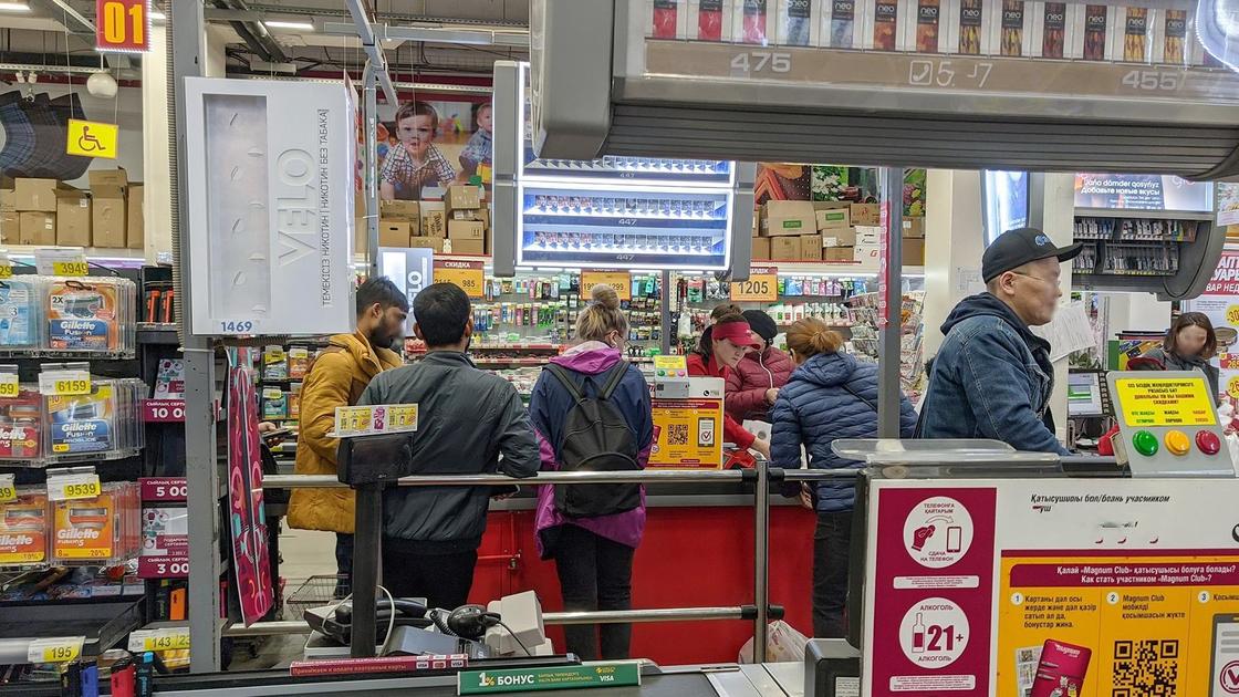 Люди стоят в очереди на кассе в супермаркете