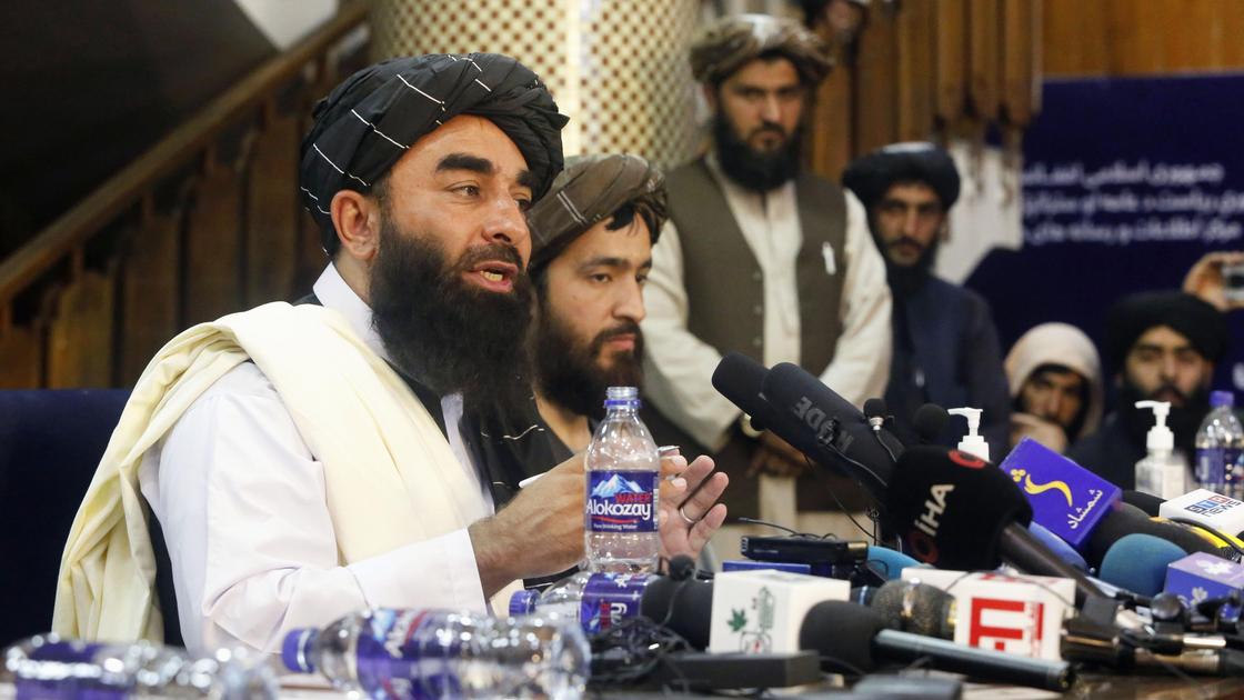 Представитель Талибана Забихулла Муджахид говорит перед микрофоном