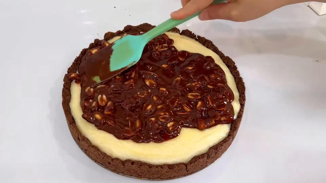 Шоколадный пирог с творогом декорируют шоколадным ганашем с орехами