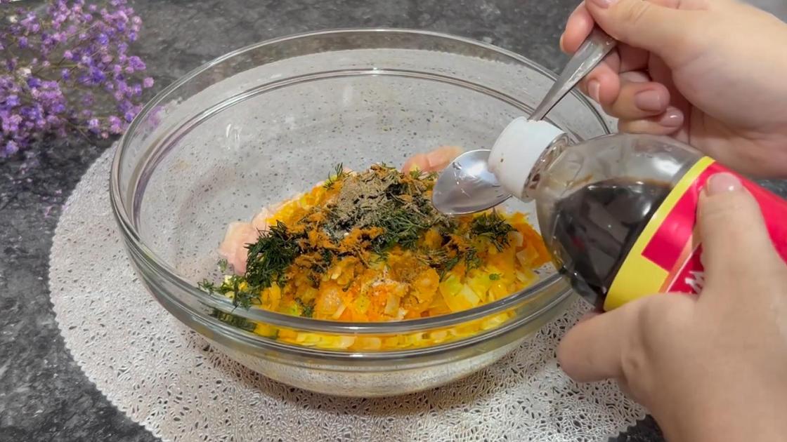 В стеклянную миску с курицей и овощами добавляют соевый соус