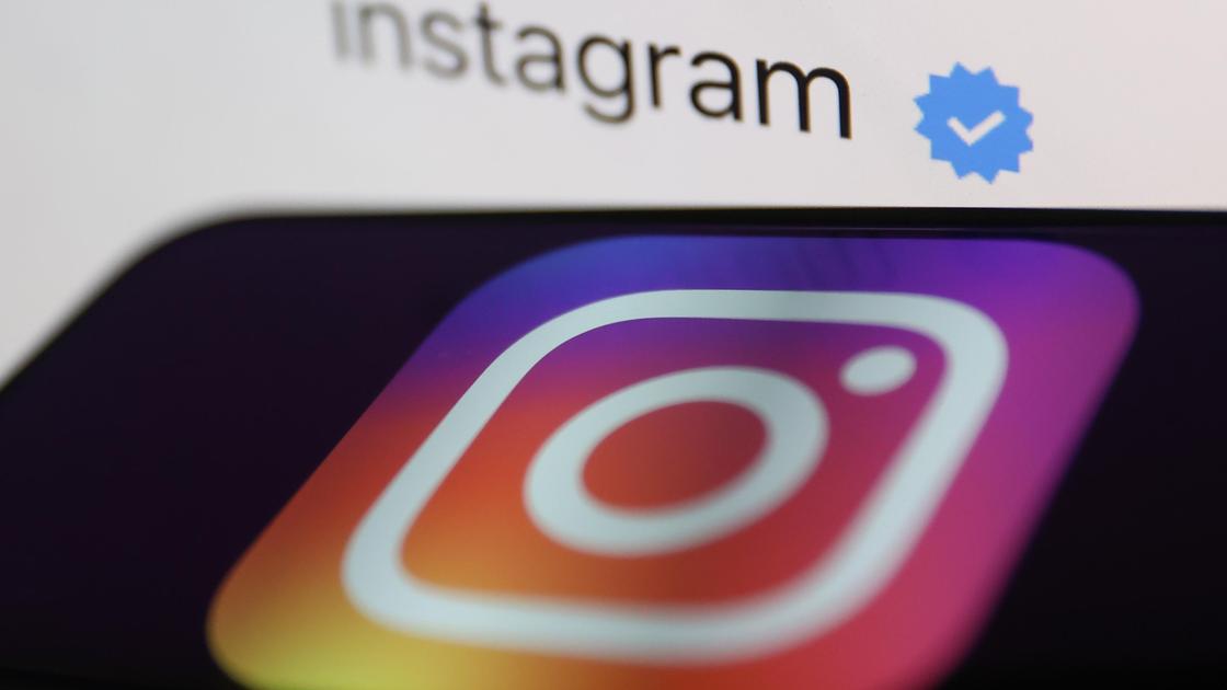 Смартфон с логотипом Instagram и синяя галочка на фоне