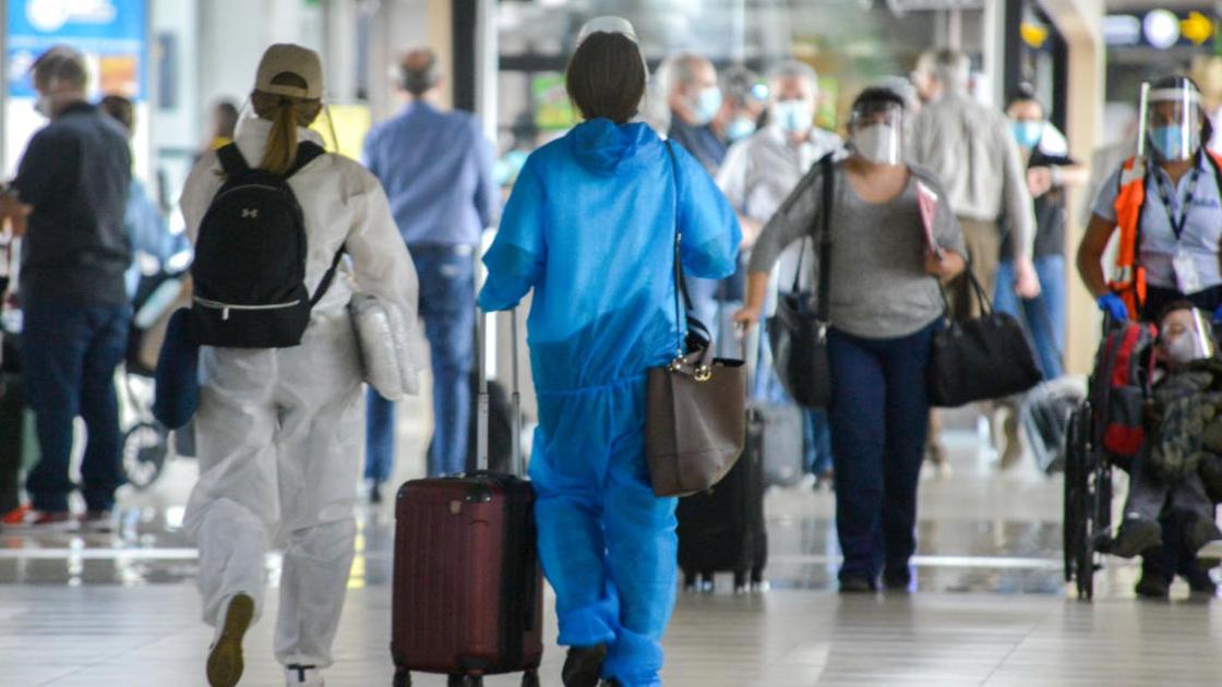 Авиапассажиры с багажом идут по холлу аэропорта