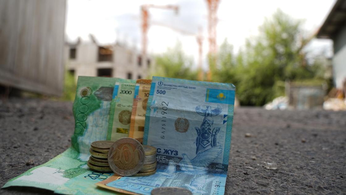Деньги лежат на земле на фоне стройки